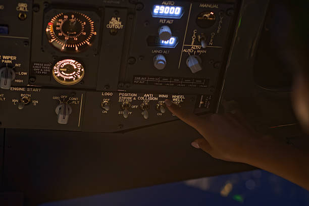 A lithe hand reaches upward and points at a flight instrument in a commercial jet cockpit.