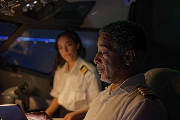 istock Portrait of a Pilot in the Cockpit Working with His Co-Pilot Before Takeoff - Night 2210790067
