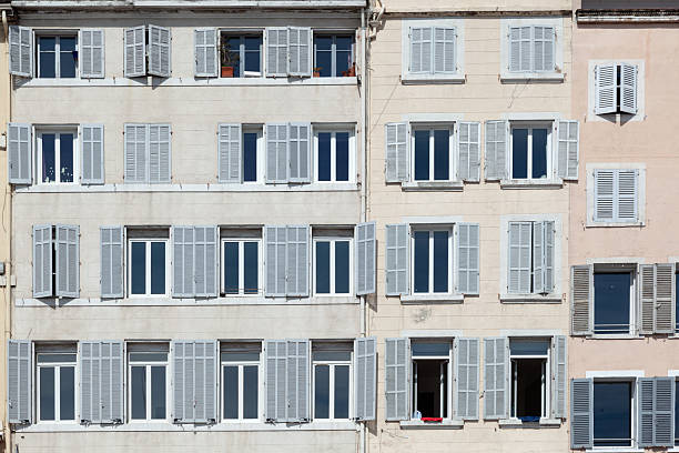 typical facade of an old hotel with open and closed shutters in traditional style