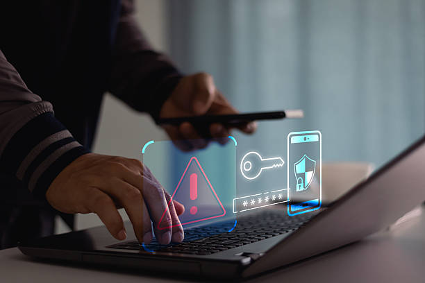 istock Cyber crime and cyber security alert warning concept. Hand using laptop and smartphone with 2 step verification for identity identification, multi factor authentication, information secure encryption. 2210792537