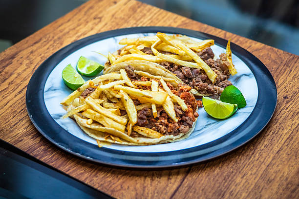 Mexican beef jerky tacos with fries on top and lemons on the side, tacos from Mexico City and Mexico State, edomex