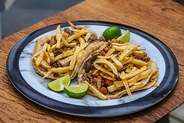 Mexican beef jerky tacos with fries on top and lemons on the side, tacos from Mexico City and Mexico State, edomex