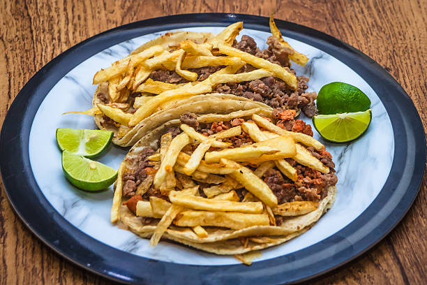 Mexican beef jerky tacos with fries on top and lemons on the side, tacos from Mexico City and Mexico State, edomex