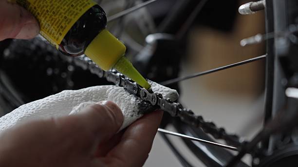 istock Close Up of Hands Oiling Commuter Bicycle Chain At Home 2210799984