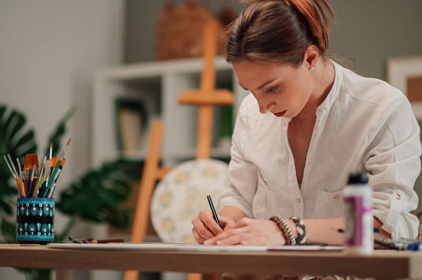 istock Young artist drawing sketches in her art studio 2210800258