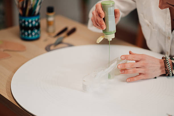 istock Artist pouring green paint on a white surface for fluid art 2210800261