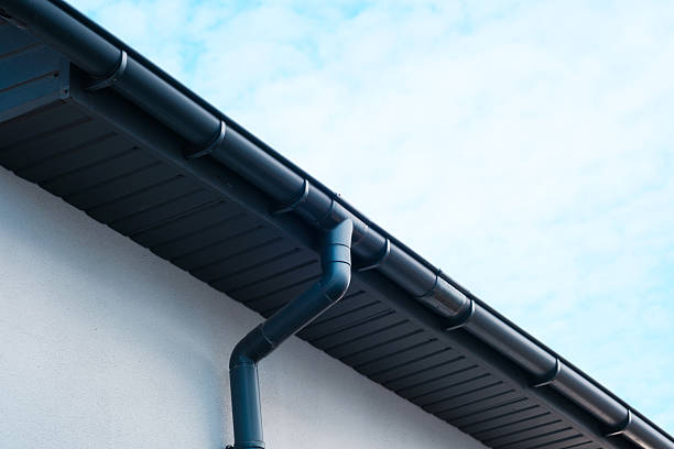 istock Roof guttering system installed on a residential building under a clear sky 2210800365
