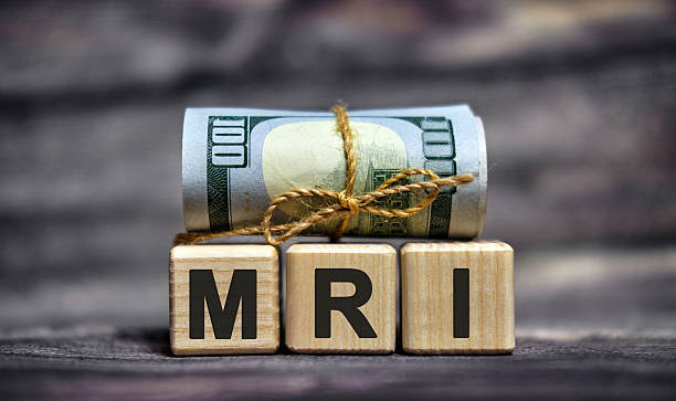istock MRI - text on wooden cubes with dollars 100 bills 2210800582