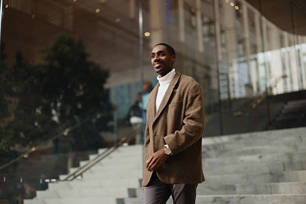Confident Man Walking Near Modern Building in an Urban Environment