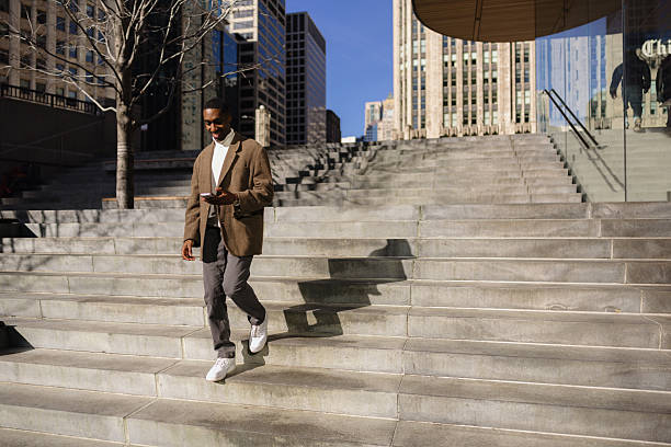 istock Man Walking Down Stairs in City While Checking Phone 2210800744