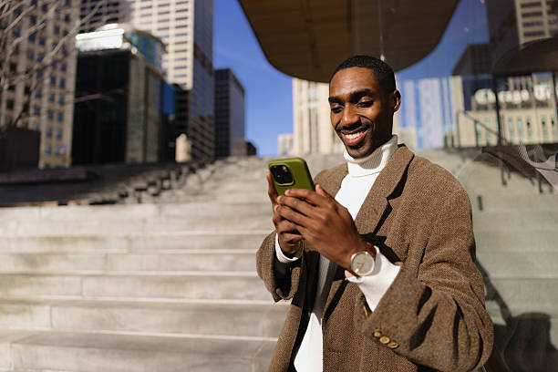 istock Smiling Man Using Smartphone Outdoors in Urban City Environment 2210800761