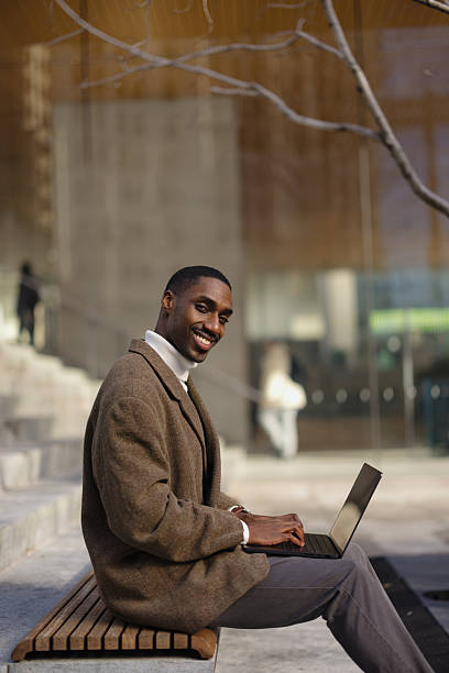 istock Business Professional Working on a Laptop Outdoors on a Bench 2210800773