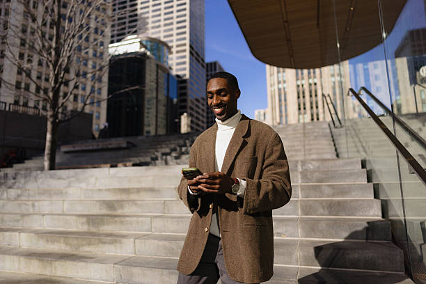 istock Businessman Walking Outdoors Using Smartphone in Urban Downtown Setting 2210800785