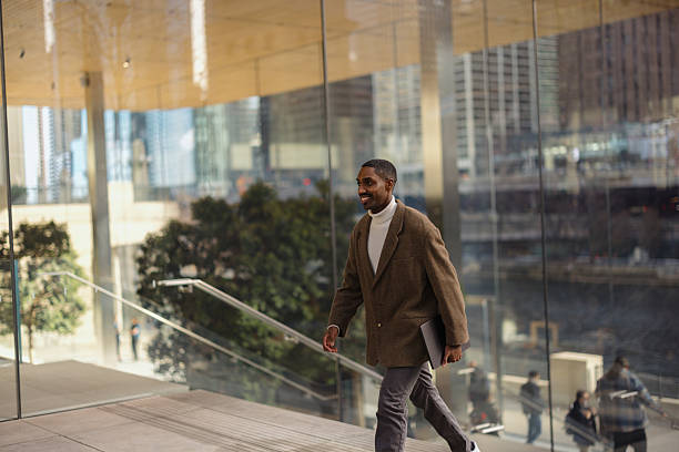 istock Smiling Professional Walking Indoors with Urban Skyline View 2210800809