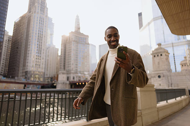 istock Happy Man Checking His Smartphone While Walking in Urban Cityscape 2210800823