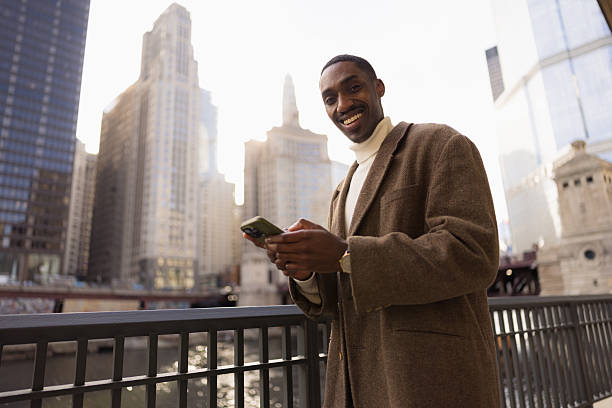 istock Smiling Professional with Smartphone in Urban Outdoor Setting 2210800847