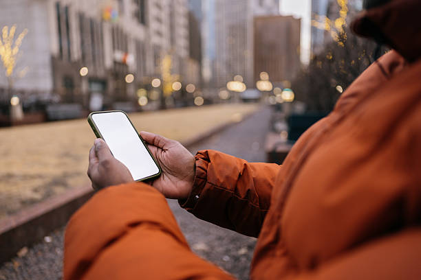 istock Person Using Smartphone in City Park with Urban Background 2210800926