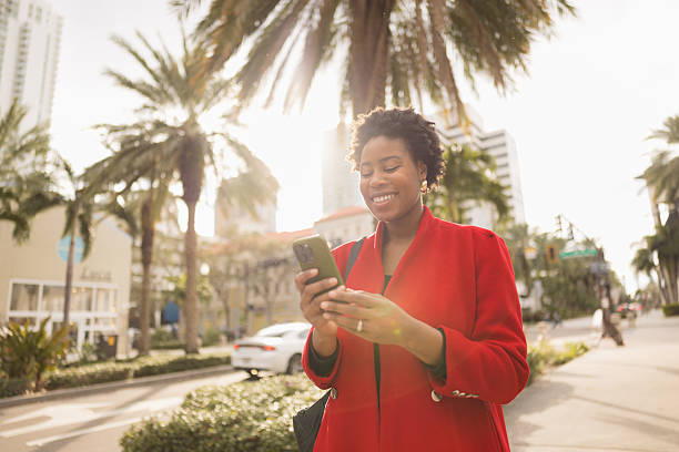 istock Smiling Woman Texting on Smartphone Outdoors on a Sunny Day 2210800940