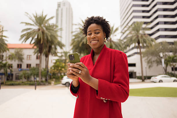 istock Cheerful Woman Using Smartphone Outdoors in Urban Setting 2210800944