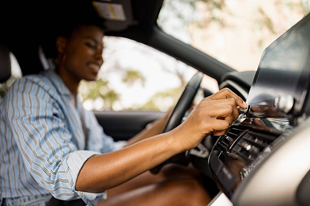 istock Woman Adjusting Car Audio Controls While Sitting in Driver's Seat 2210800961