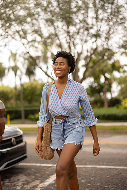 istock Smiling Woman in Casual Chic Walking Outdoors on a Sunny Day 2210800984