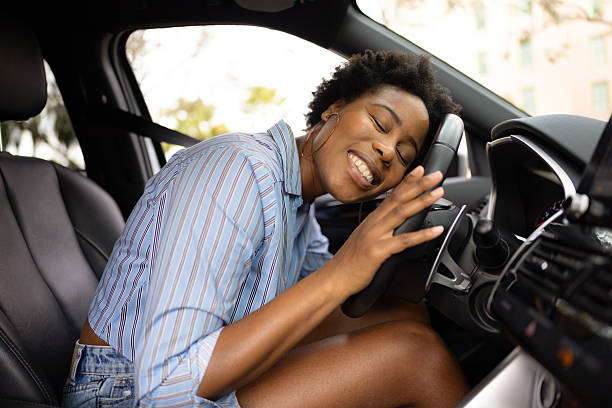 istock Joyful Woman Embracing Her Car While Sitting In the Driver's Seat 2210800986