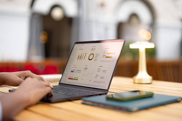 istock Person Analyzing Business Data on a Laptop at an Outdoor Table 2210800997