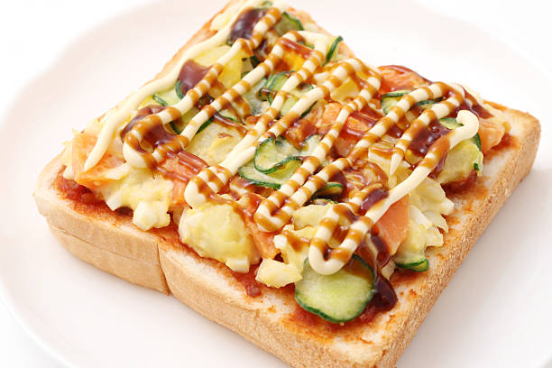 potato and vegetables mayonnaise salad served on plain bread and baked in a plate
