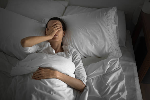 istock Woman lying down in bed feeling sick, headache, stomachache. 2210803782
