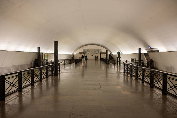 Lisbon, Portugal. 14 April 2025. Interior of Rato metro station with people walking along the wide corridor toward the platforms.