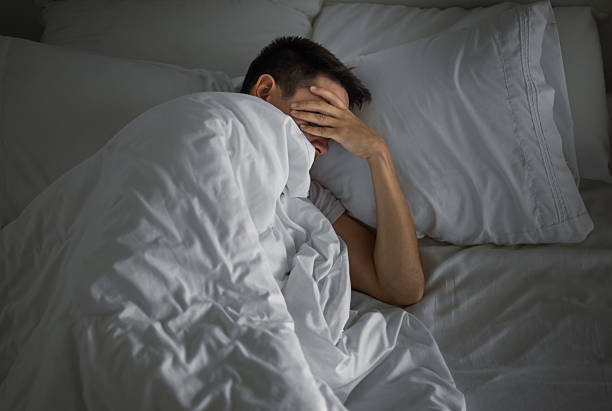istock Sleepless tired man lying in bed feeling stressed. Insomnia. 2210803826