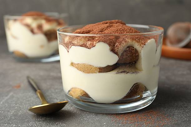 istock Delicious tiramisu in glass on grey table 2210804862