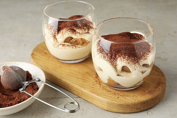 istock Delicious tiramisu in glasses on light table 2210804964