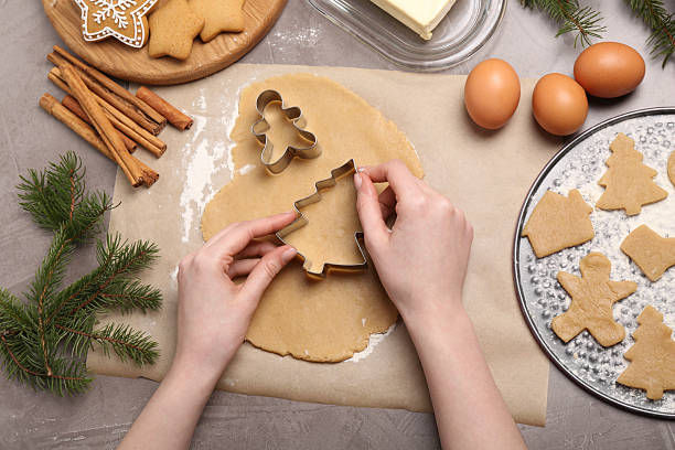 istock Woman making Christmas cookies with cutters at grey table, top view 2210805007
