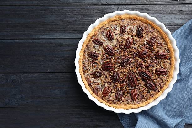 istock Delicious pecan pie in baking dish on dark wooden table, top view. Space for text 2210805050