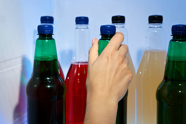 Woman taking bottle with drink from refrigerator, closeup