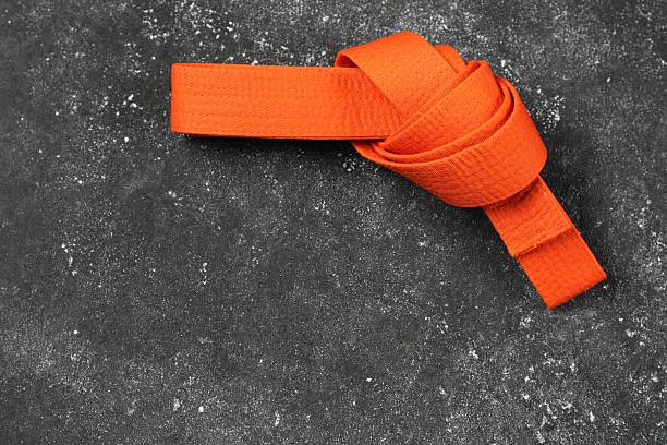 Brown martial art belt tied in a knot on blue background