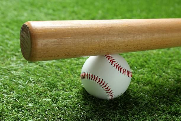 istock Baseball ball and bat on green grass outdoors, closeup 2210807283