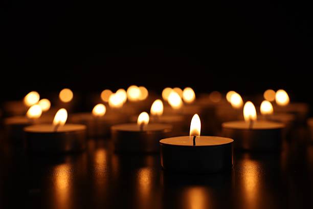 istock Burning candles on dark surface against black background, closeup 2210808057