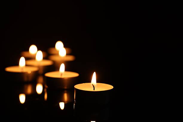 istock Burning candles on mirror surface in darkness, closeup. Space for text 2210808067