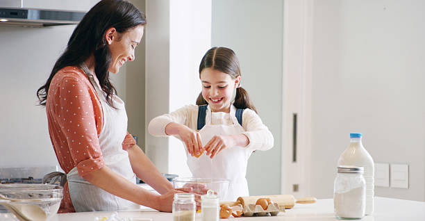 istock Happy, baking and mother with child in kitchen with dough for learning with cookies or biscuits. Tray, eggs and mom teaching girl kid to cook with ingredients and utensils for dessert in home. 2210808336