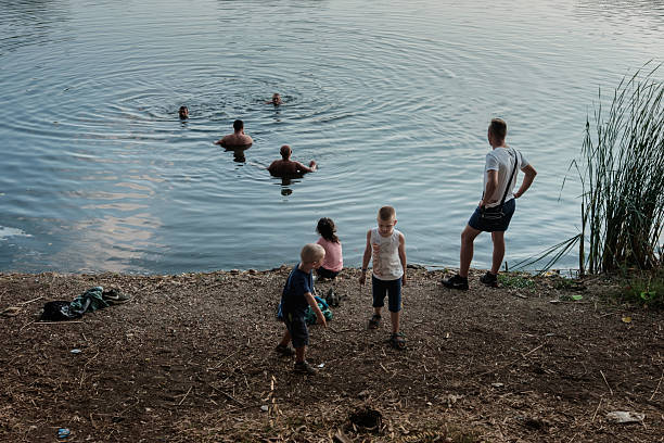 In the heart of the province of Caserta, on the quiet shores of Lake Falciano, a family of foreigners enjoys a carefree moment. The adults dive into the clear water, creating perfect circles on the surface, while the little ones play on the shore, curious and happy. A simple but intense scene, which tells of summer, freedom and life shared in contact with nature.