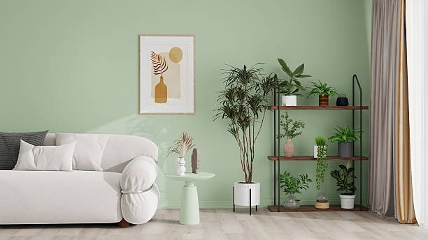 istock Modern living room with light green walls, featuring a white sofa with wooden frame, houndstooth pillows, abstract wall art, a wooden side table, and a black metal shelf with green plants 2210817672