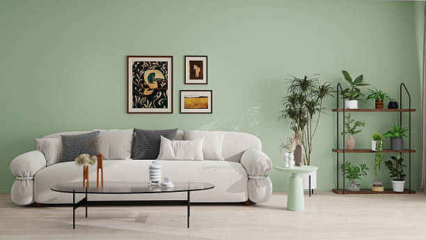 istock Modern living room with light green walls, a white sofa, black coffee table, and decorative items. Wooden shelves with green plants and framed abstract art add a stylish touch. Cozy and inviting atmosphere. 2210817695