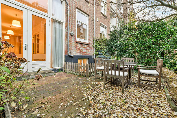 a set of wooden table and chairs in the beautiful green garden of the house