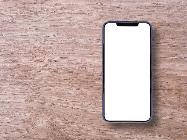 istock Top view, flat lay of a smartphone with a blank white screen on a light-colored wooden surface. Minimalist composition. Concept for business, online, blogger, and advertising. 2210819796