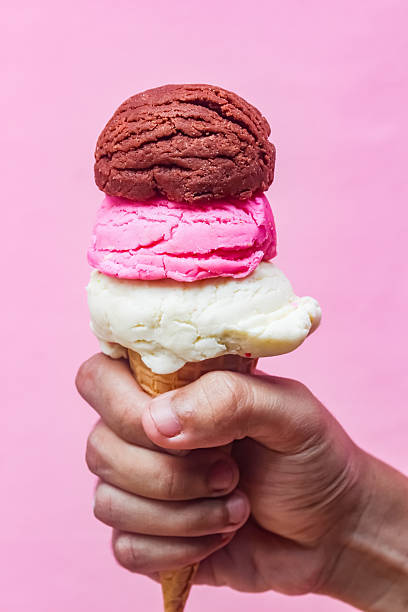 istock hand holding a stack of ice cream cones on a pink background 2210819891
