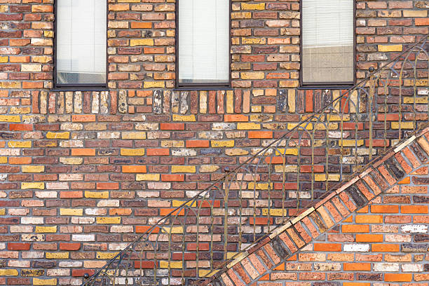 Brightly colored brick wall with a window and stairs in an urban setting