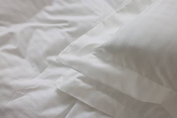istock Bed with clean linens and pillows at home, closeup 2210826536
