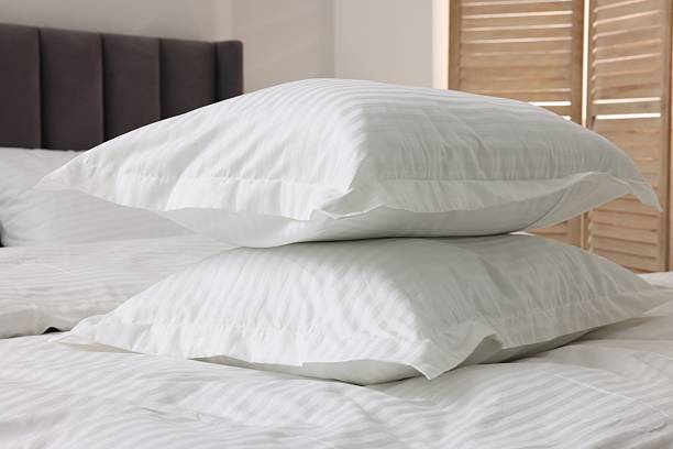 istock Bed with clean linens and pillows at home 2210826547